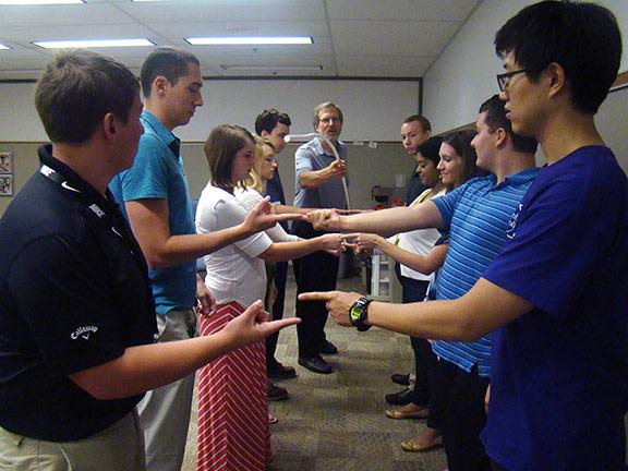 2016 Interns participate in a group icebreaker during a weekly meeting.